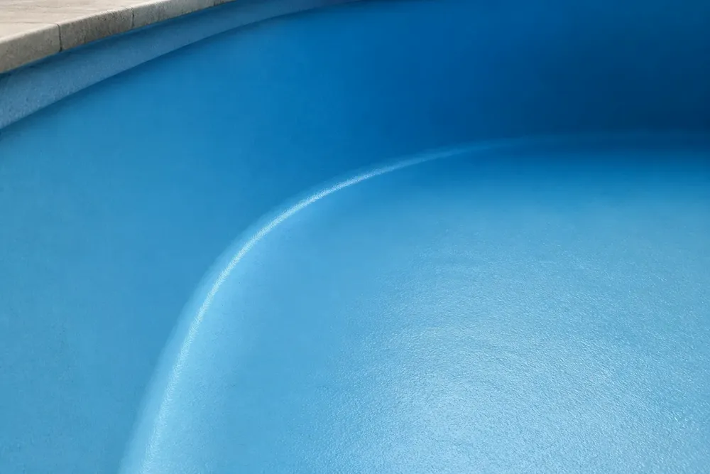 Acabamento interno liso de uma piscina azul